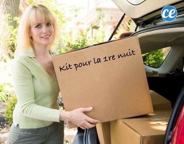 Femme tenant un carton identifié « Kit pour la 1re nuit » lors d'un déménagement