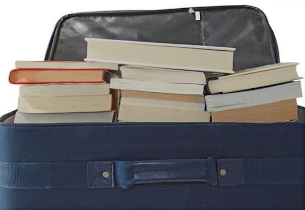 Livres empilés sur une valise à roulettes pour éviter de soulever des cartons trop lourds