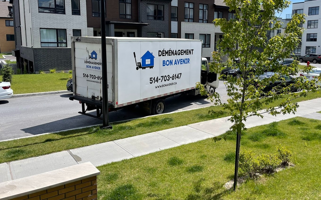 Camion de Déménagement Bon Avenir stationné devant des maisons de ville dans un quartier résidentiel