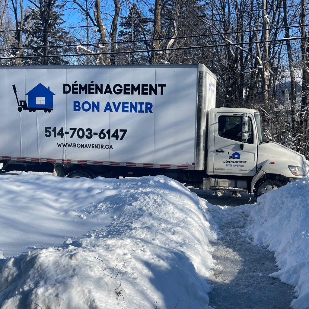 Camion de déménagement Bon Avenir sur une route enneigée, prêt pour un déménagement longue distance